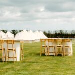 Receptieopstelling met tenten voor overnachting bij exclusieve trouwlocatie