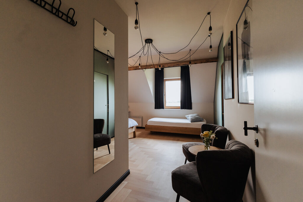 Luxe kamer in hotel lo-reninge met elegant interieur, zithoek en warme afwerking