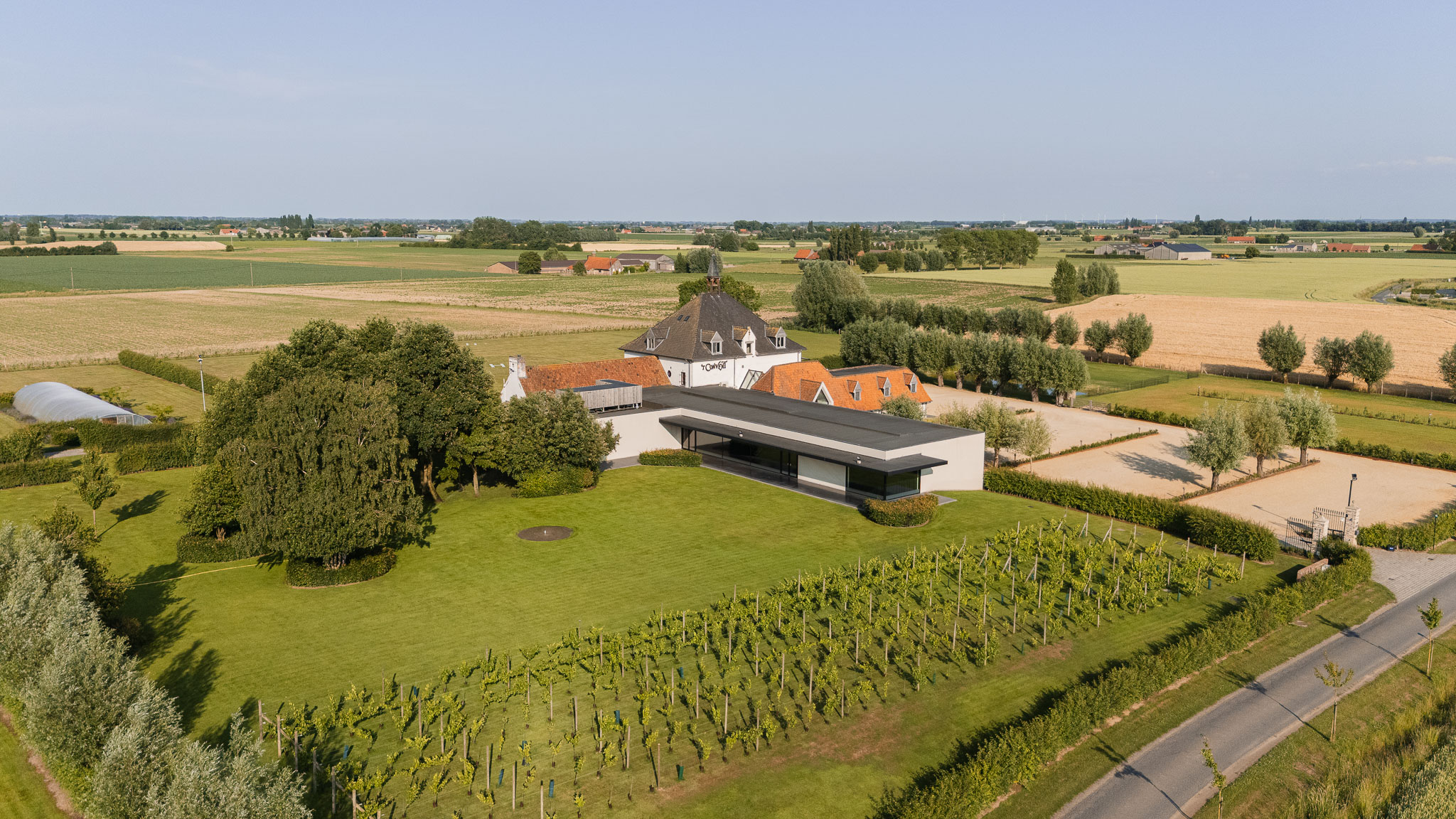 Luchtbeeld van het domein van 't Convent met wijngaard, tuin en velden in de Westhoek